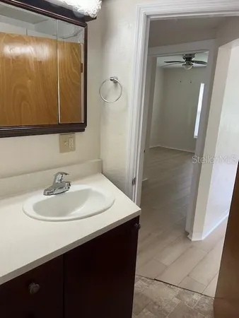 an empty room with a window and a ceiling fan