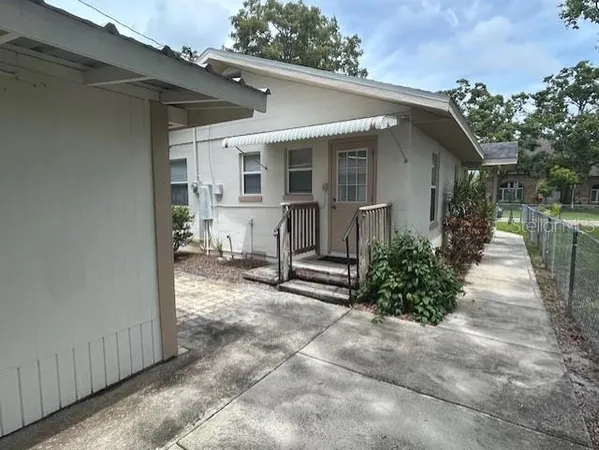 a view of house with backyard and sitting area