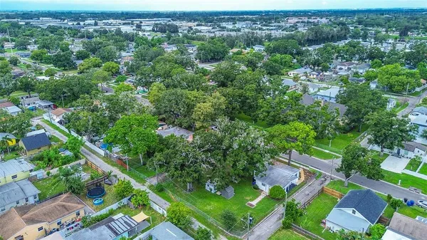 an aerial view of residential houses with outdoor space and trees