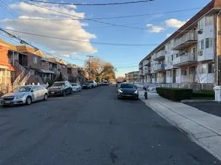 a view of building with cars parked across