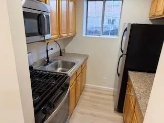 a bathroom with a granite countertop sink and a washing machine