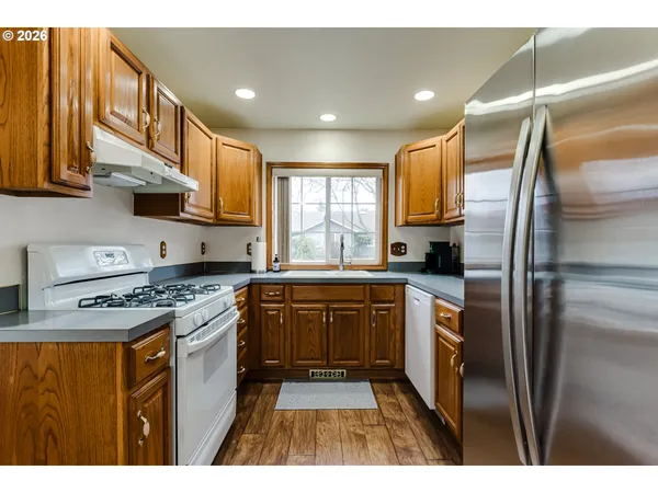 a kitchen with stainless steel appliances granite countertop a stove a sink dishwasher and a refrigerator