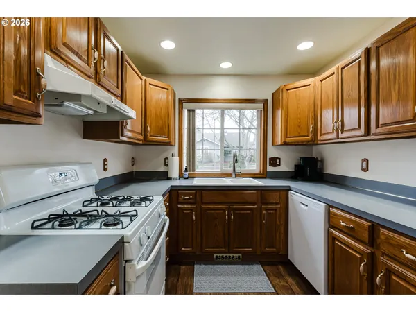 a kitchen with a sink stove top oven and cabinets