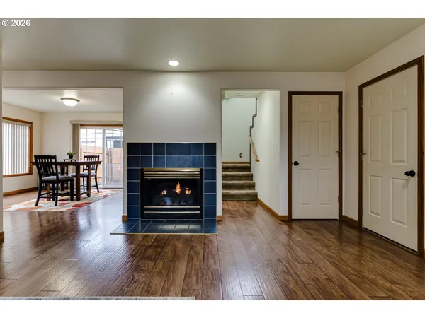 a view of a livingroom with wooden floor and a fireplace
