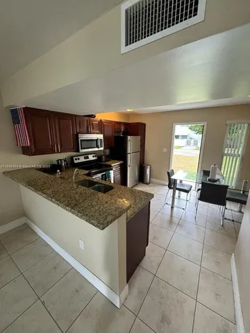 a kitchen with stainless steel appliances granite countertop a stove a sink and a microwave