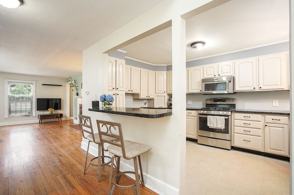 15 Holyoke Road Westfield, MA 01085 - Photo 9 of 41 a kitchen with stainless steel appliances a stove top oven a sink dishwasher and a refrigerator with wooden floor