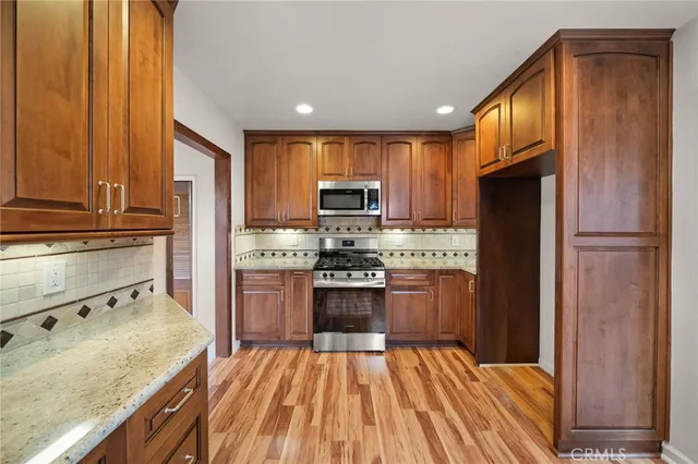 a kitchen with granite countertop stainless steel appliances and wooden cabinets