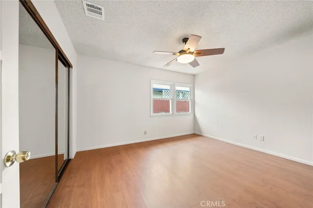 an empty room with a window and a ceiling fan