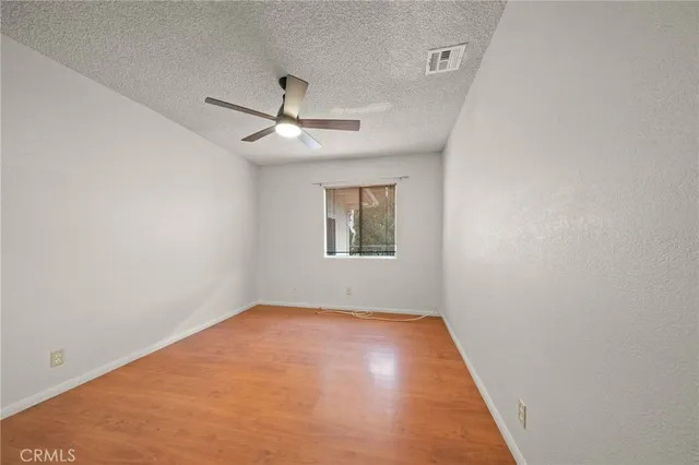 an empty room with a window and a ceiling fan