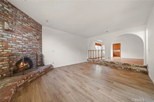 an empty room with wooden floor and fireplace