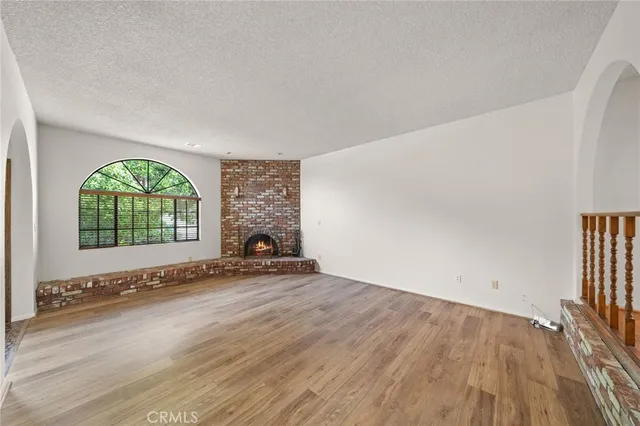 an empty room with a fireplace and windows