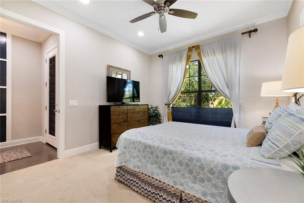 1229 Manado Drive Naples, FL 34113 - Photo 14 of 35 a bedroom with a bed a dresser and a chandelier