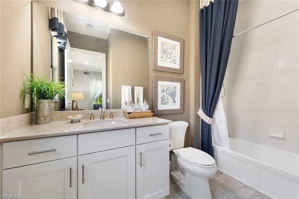 1229 Manado Drive Naples, FL 34113 - Photo 18 of 35 a bathroom with a toilet a sink a tub and mirror