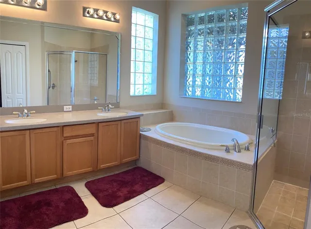 a bathroom with a tub sink and mirror
