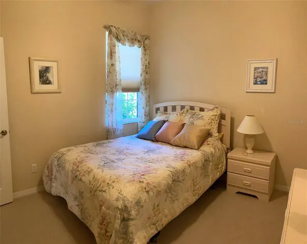 a bed sitting in a bedroom next to a window