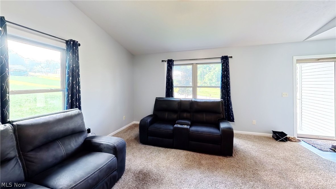 202 Home Street Rittman, OH 44270 - Photo 13 of 23 Vaulted ceiling, light neutral wall paint, carpeted flooring, multiple windows, sliding glass door