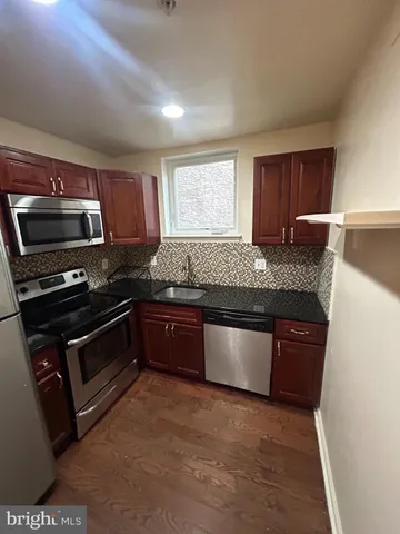 a kitchen with granite countertop a stove and a sink