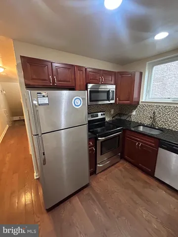 a kitchen with stainless steel appliances granite countertop a refrigerator a stove a sink and a microwave