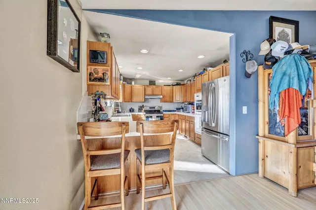 a dining room with stainless steel appliances a dining table chairs and wooden floor