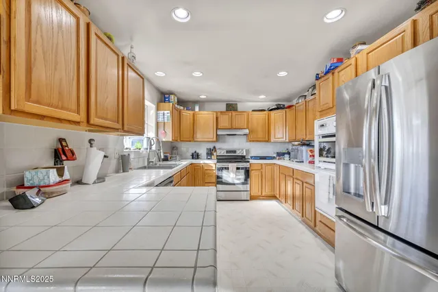 a large kitchen with stainless steel appliances lots of counter space and a sink