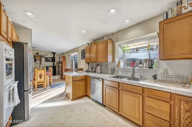 a kitchen with stainless steel appliances granite countertop sink stove refrigerator and cabinets
