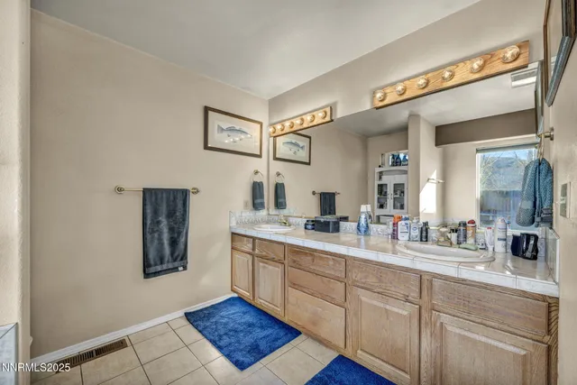 a spacious bathroom with a double vanity sink and a mirror