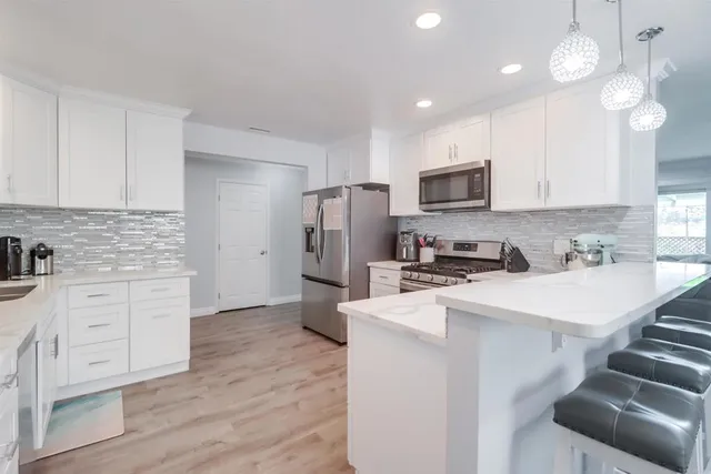 a kitchen with white cabinets and stainless steel appliances