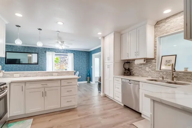 a kitchen with white cabinets appliances and a sink