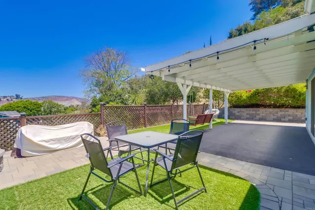 a patio with glass top table and chairs