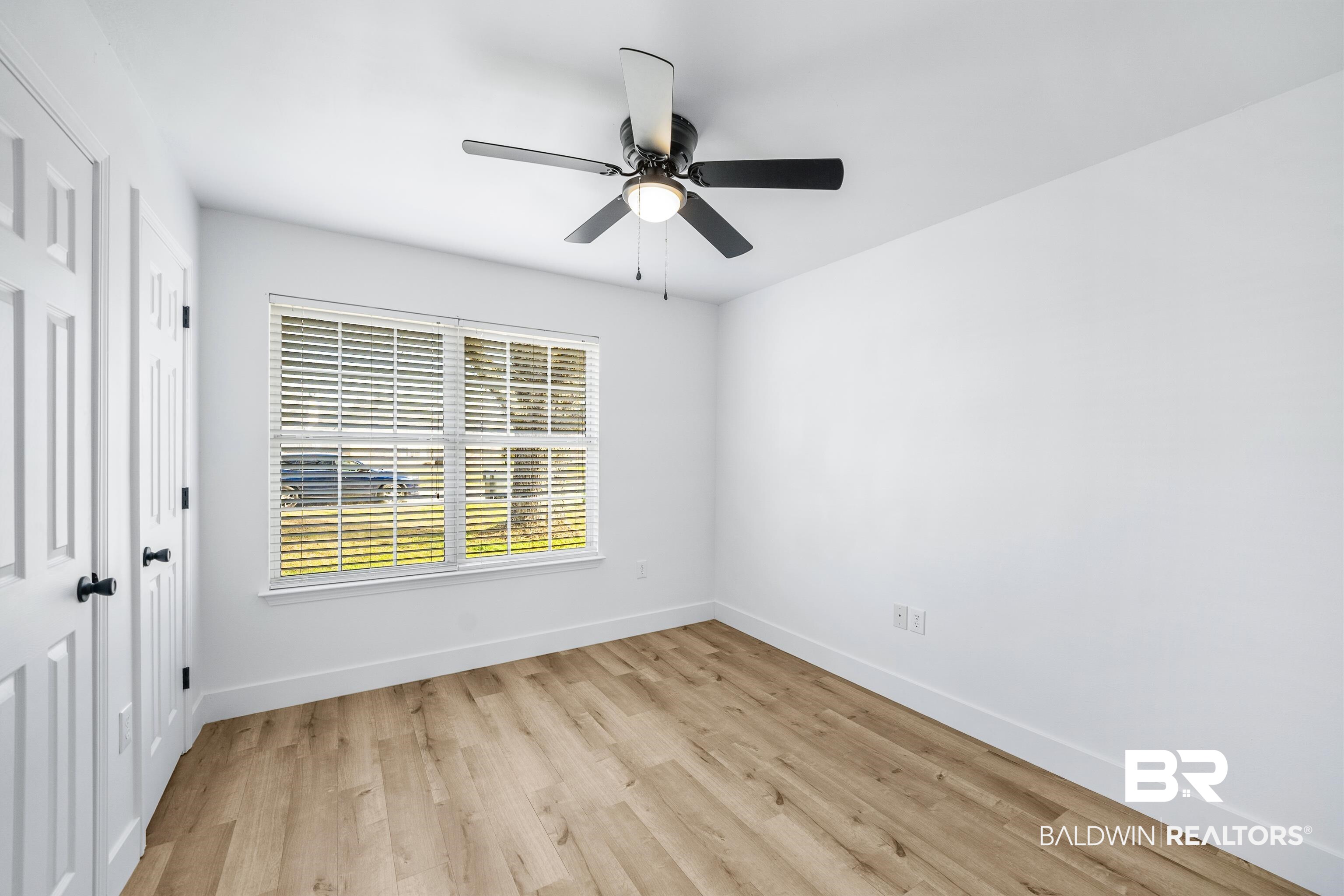 9243 Brookshire Loop Daphne, AL 36526 - Photo 13 of 26 Empty room with ceiling fan and light wood-type flooring