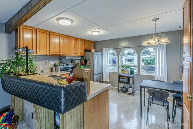 a kitchen with stainless steel appliances granite countertop a refrigerator a sink dishwasher a stove and a refrigerator