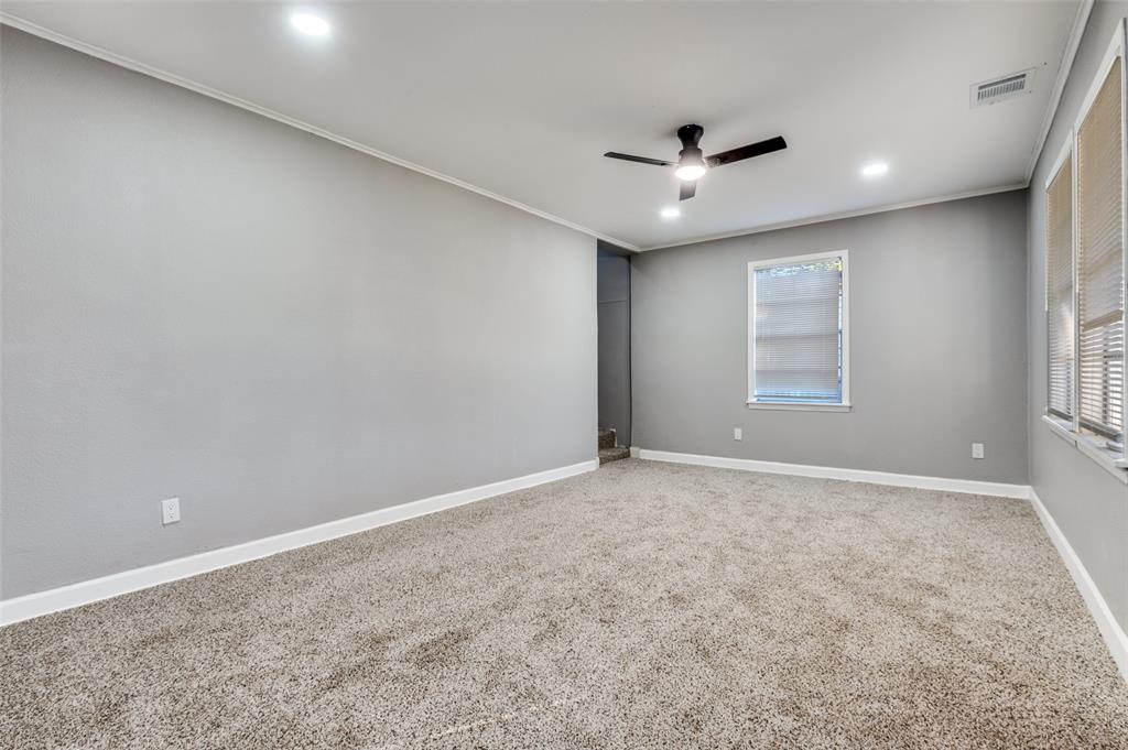 421 West 8th Street Lancaster, TX 75146 - Photo 11 of 25 an empty room with windows and ceiling fan