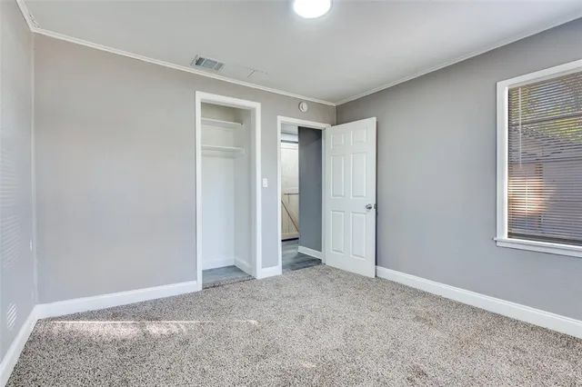 an empty room with windows and closet