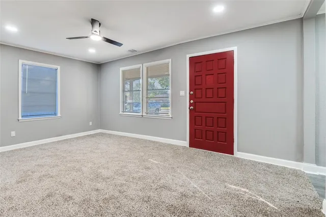 an empty room with windows and cabinet
