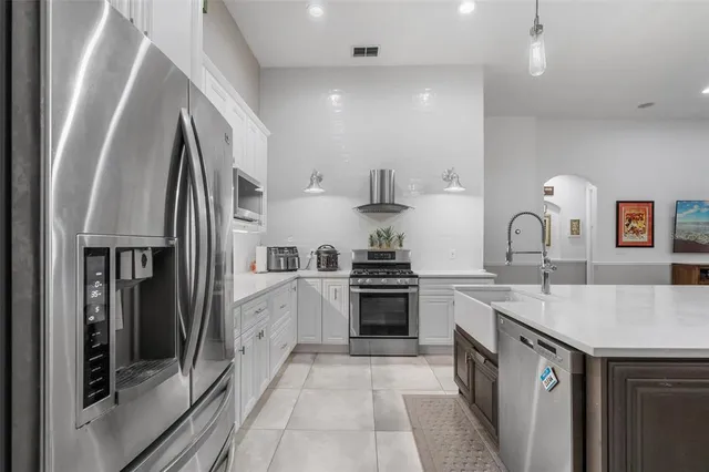 a kitchen with a sink dishwasher a stove and a refrigerator with wooden floor