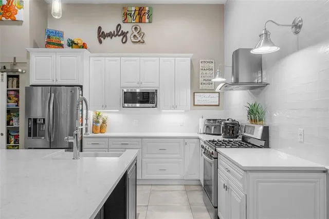 a kitchen with white cabinets and stainless steel appliances