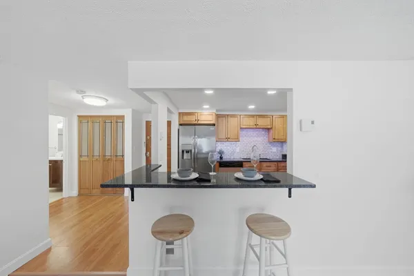 a kitchen with stainless steel appliances granite countertop a sink cabinets and wooden floor