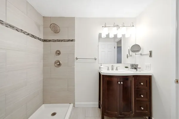 a bathroom with a sink mirror and shower
