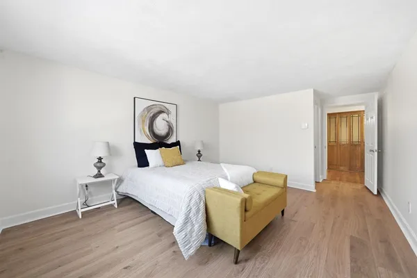 a bed room with a bed and painting on the wall