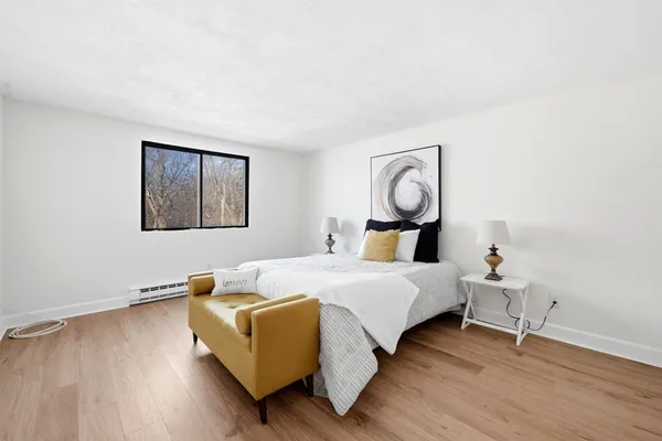 a bedroom with a bed and wooden floor