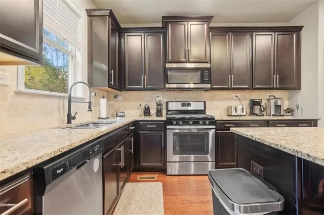 a kitchen with kitchen island a sink stove and refrigerator
