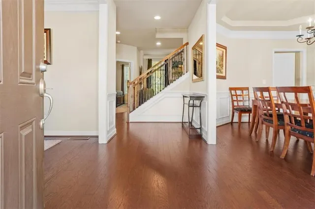 a living room with stainless steel appliances wooden floor and a large window