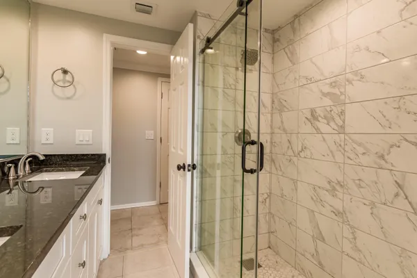a bathroom with a sink shower and a mirror