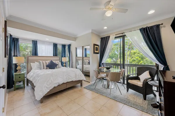 a bedroom with a bed and large windows