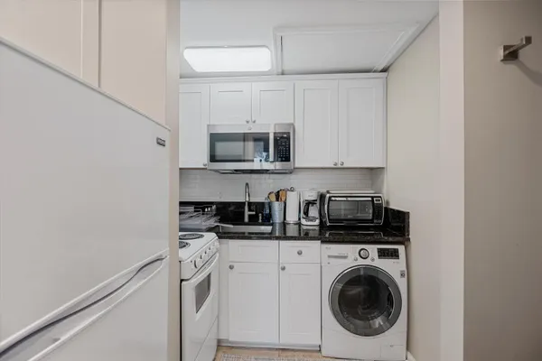 a kitchen with stainless steel appliances a sink a stove a microwave and cabinets