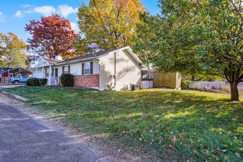 a front view of house with yard and trees all around