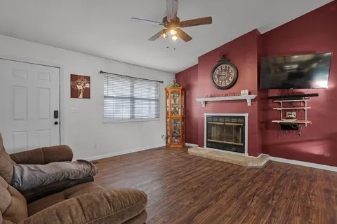 a living room with furniture a flat screen tv and a fireplace