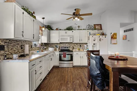 a kitchen with a refrigerator and white cabinets