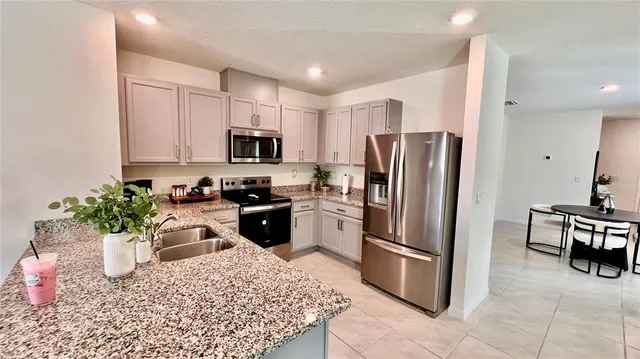 a kitchen with a refrigerator a microwave a sink and cabinets