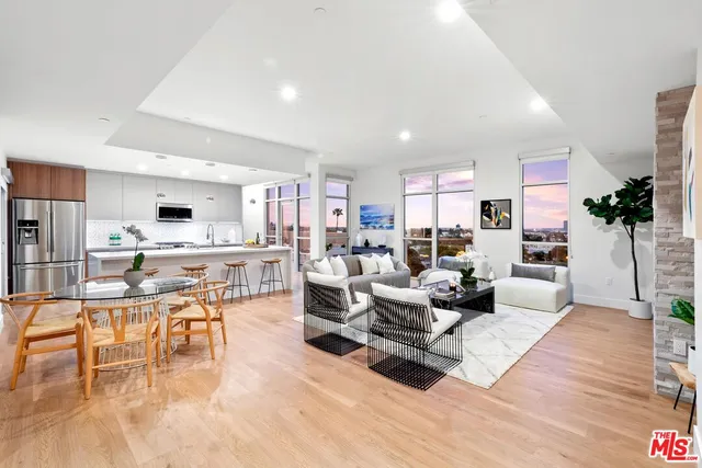 a living room with furniture and a dining table with kitchen view
